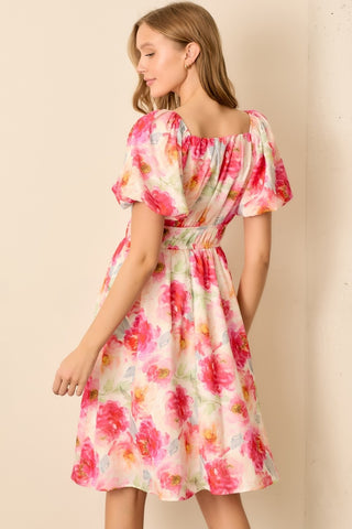 Woman wearing a floral dress against a beige background