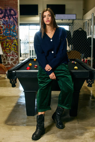 Woman sitting on a pool table in an urban setting with graffiti on the wall.