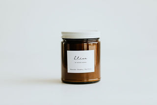 Brown candle jar with a white label on a light gray background