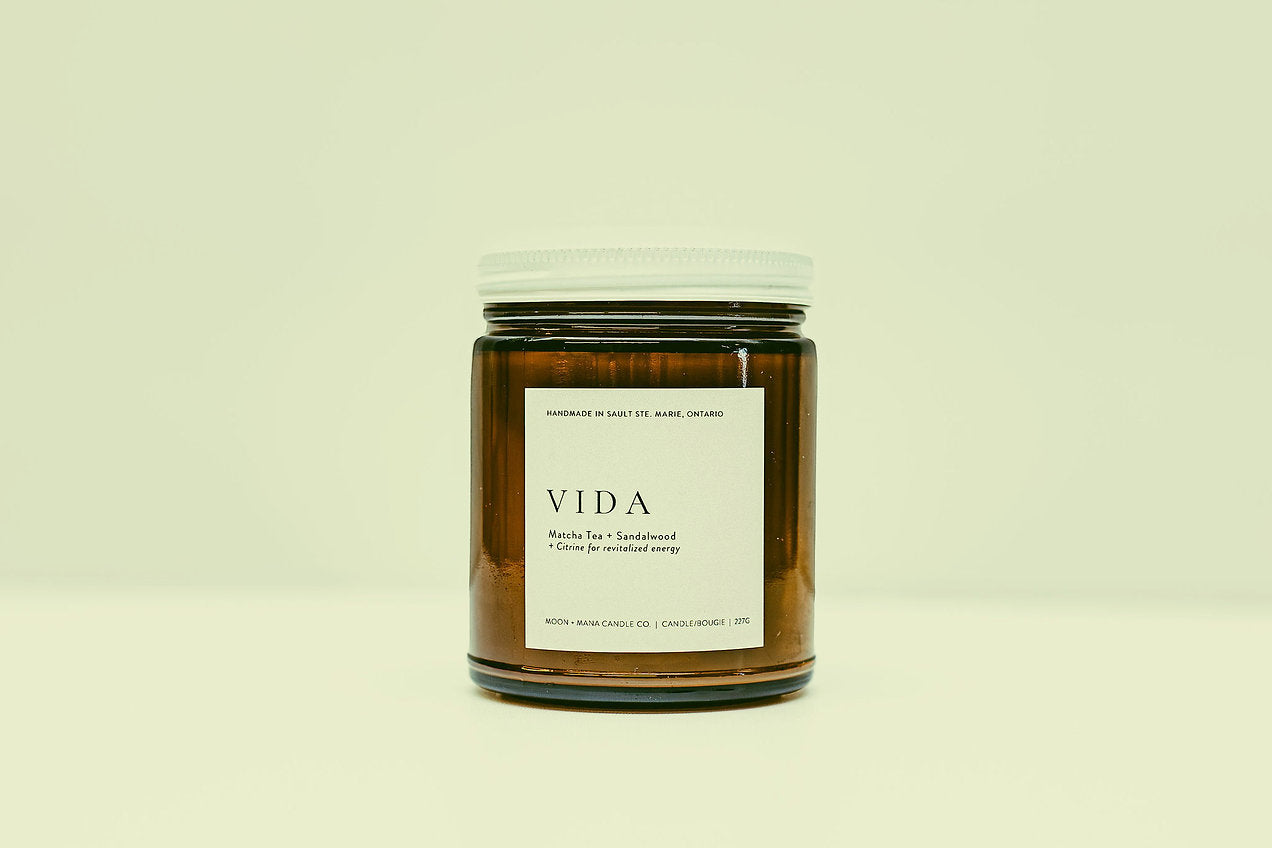 Brown candle jar with 'VIDA' label on a beige background