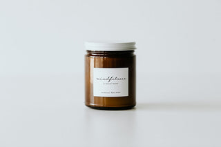A brown jar candle with a white lid, labeled 'Mindfulness', on a white background.