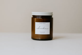 Jar of 'Luminance' candle with a white label on a beige background