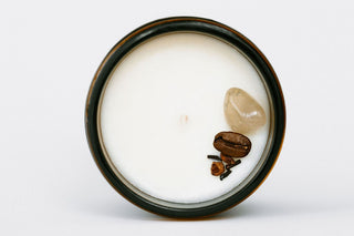 Candle with coffee beans and a heart-shaped object on a white background