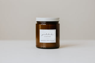 A jar candle with a white label on a neutral background.