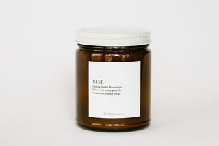 Candle jar labeled 'RISE' on a white background