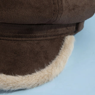 Close-up of a brown and beige winter hat on a light blue background