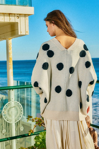 Woman wearing a polka dot sweater by the ocean