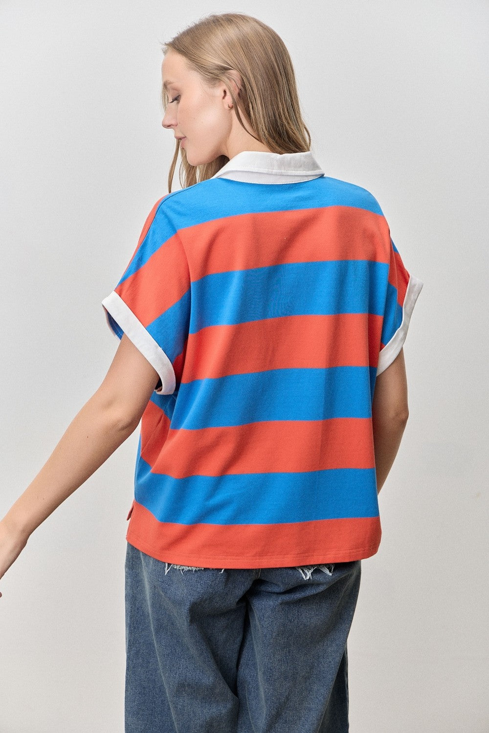 Person wearing a red and blue striped shirt with a plain background