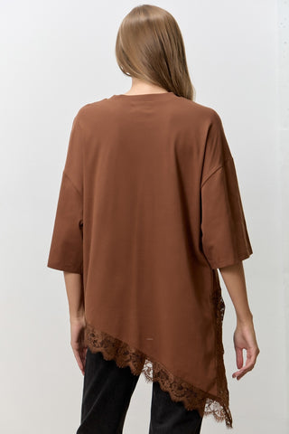 Women wearing a brown t shirt with Lace Trim against a neutral background. 