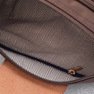 Close-up of a brown leather bag with a herringbone pattern interior.