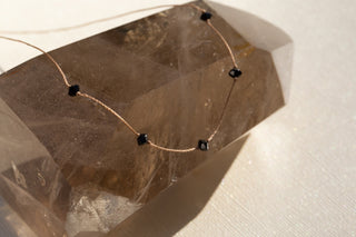 a black crystal necklace on nylon