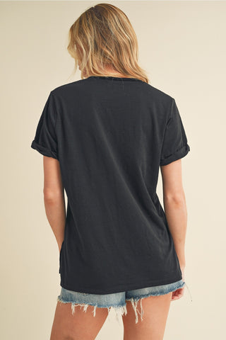 Person wearing a black t-shirt and denim shorts on a beige background