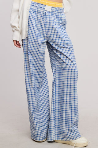Person wearing blue plaid pants on a plain background