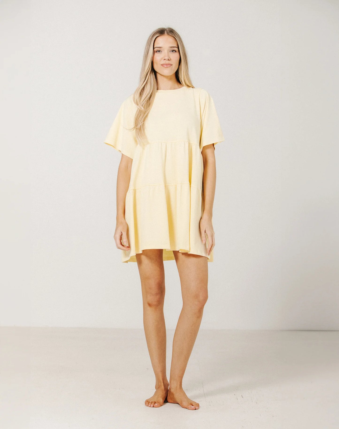 Woman wearing a yellow dress against a white background