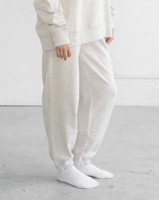 Women wearing an oversized jogger against a neutral photo backdrop. 