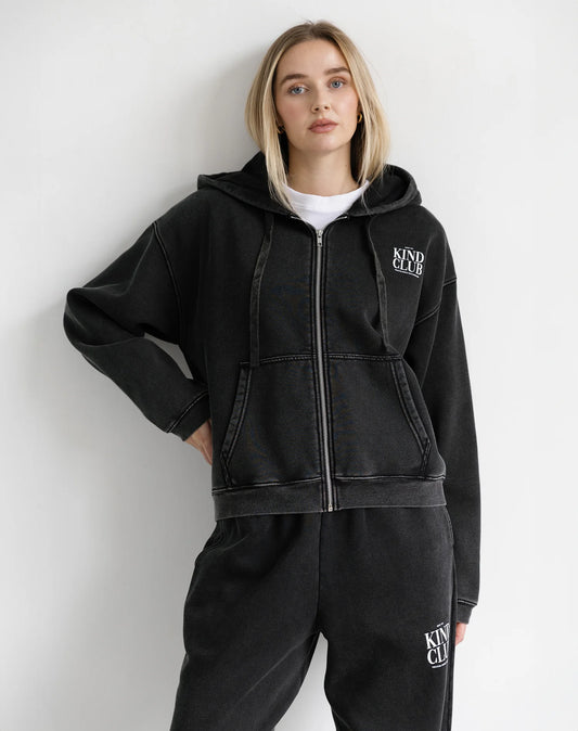 Person wearing a black hoodie and pants with 'KIND CLUB' logo on a white background