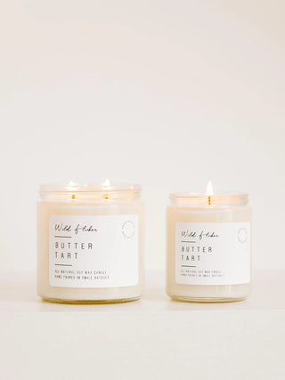 Two lit jar candles labeled Wild of Candles Butter Tart on a clean white background.
