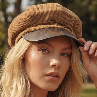 Person wearing a brown corduroy cap outdoors