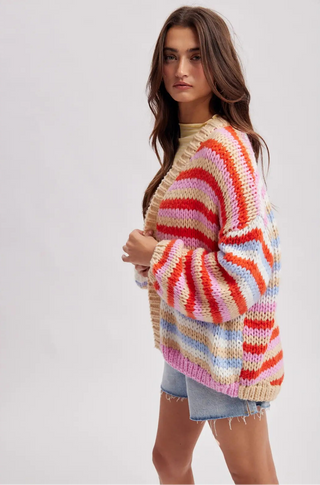 Woman wearing a colorful striped sweater on a plain background