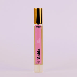 Perfume bottle with pink label and gold cap on a light purple background