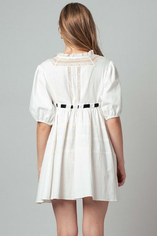 White dress with lace details on a gray background