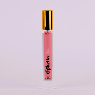 Lip gloss with gold cap and pink label on a light purple background