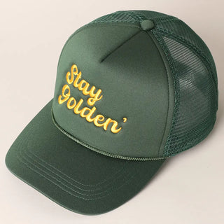 Green cap with 'Stay Golden' text on a beige background