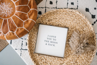 wooden sign on a wicker bench that says "i love you to the moon & back"