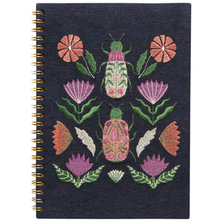 Embroidered notebook with floral and insect design on a dark background