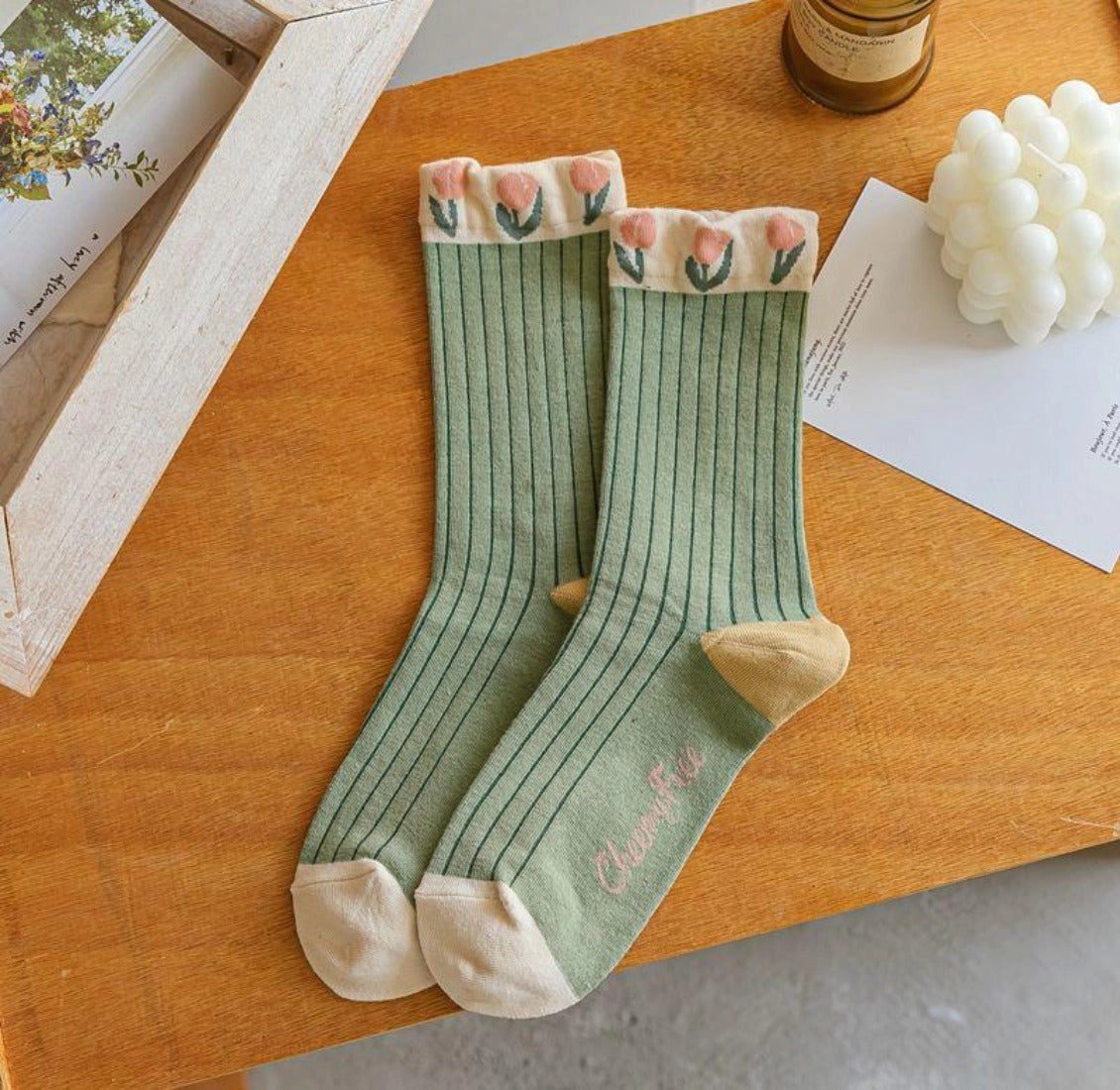 Green socks with floral cuffs on a wooden surface