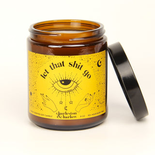 Brown candle jar with yellow label featuring text and symbols on a white background