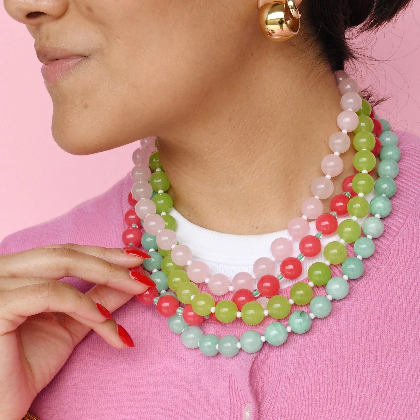 Women wearing layered colourful beaded necklaces. 