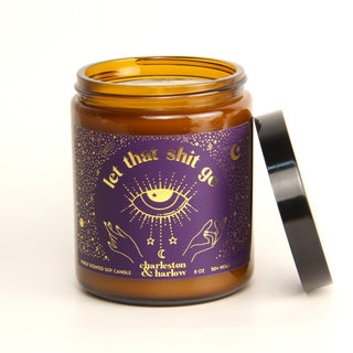 Candle jar with purple label and black lid on a white background