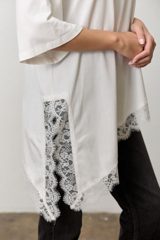 Women wearing a brown t shirt with Lace Trim against a neutral background. 
