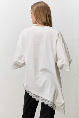 Women wearing a white t shirt with Lace Trim against a neutral background. 