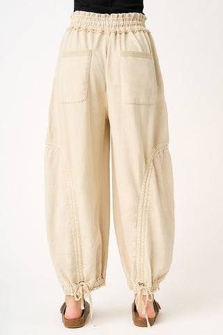 Beige baggy pants with elastic waistband on a white background