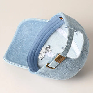Blue denim cap with a brand logo on a beige background