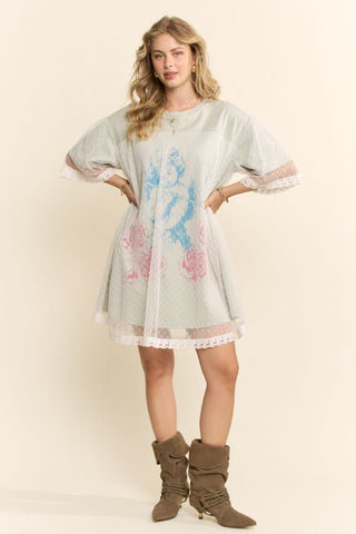 Women modelling a sage green mini dress with a lace overlay against a neutral photo backdrop.