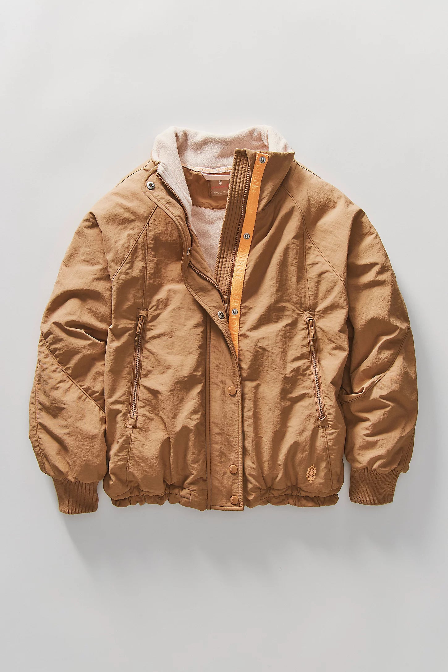Brown jacket with a white shirt underneath on a light gray background