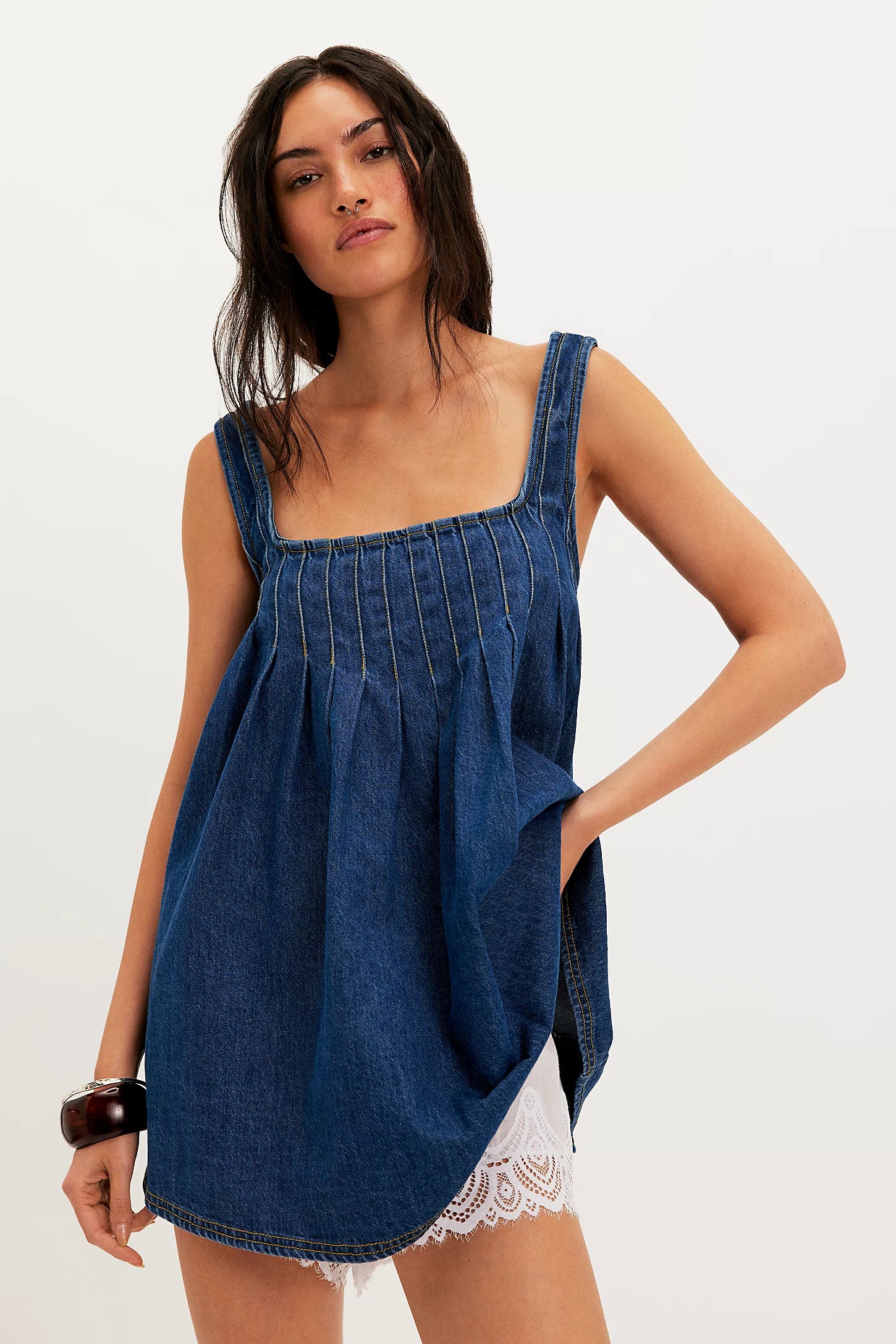 Woman wearing a blue denim dress on a white background