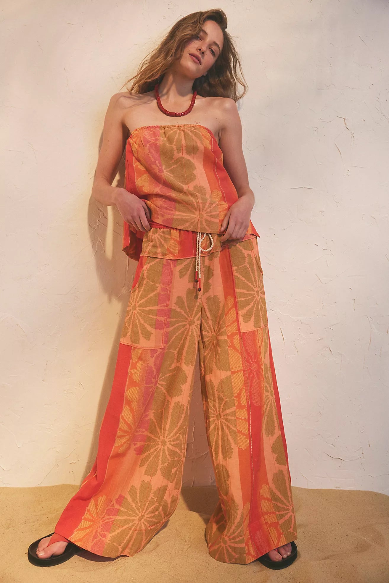 Woman wearing a floral jumpsuit against a plain background