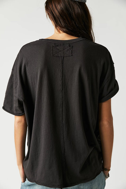Person wearing a black oversized t-shirt on a plain background