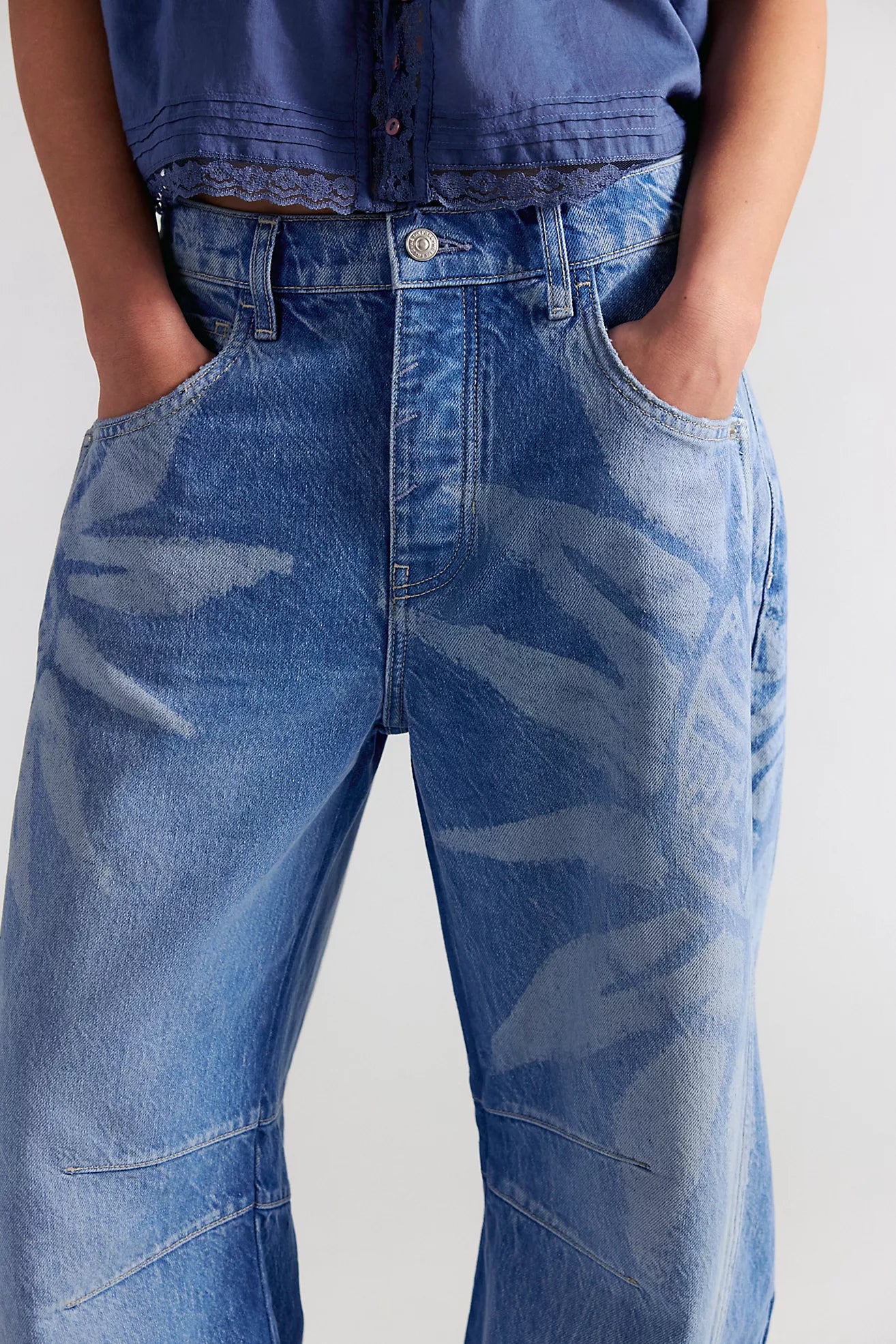 Person wearing blue jeans with a plain background