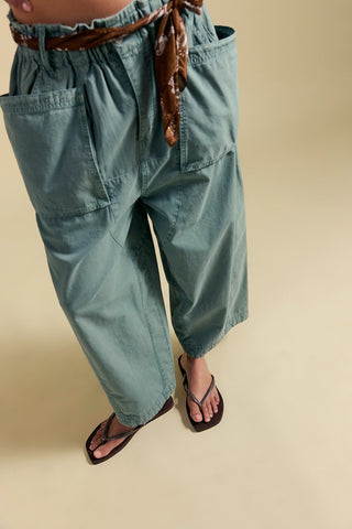 Light blue baggy pants with a belt on a beige background
