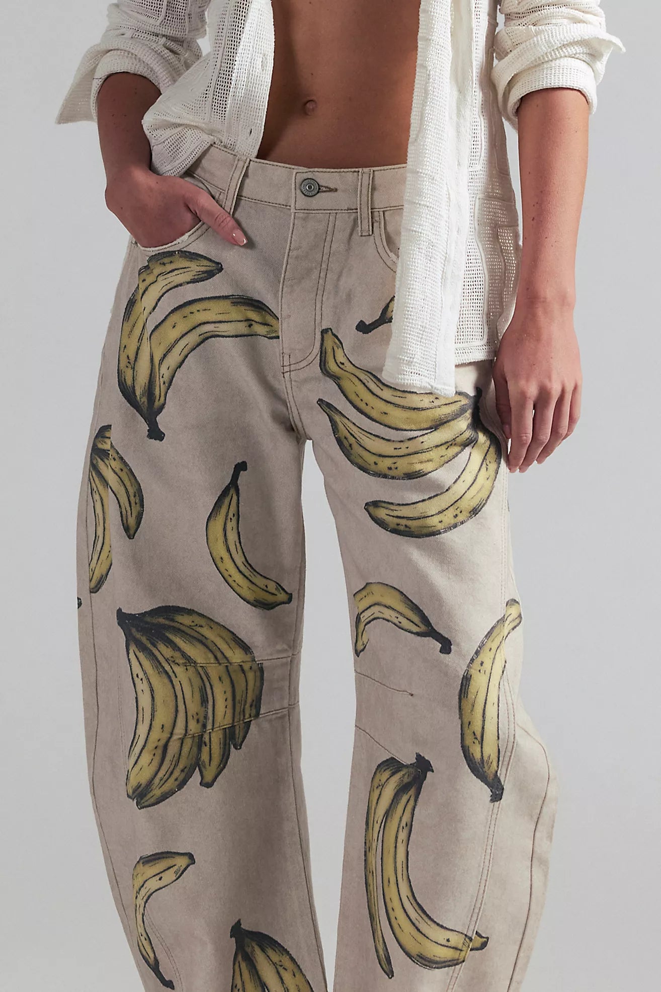 Person wearing beige pants with banana pattern and a white shirt.