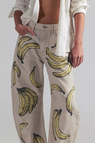 Person wearing beige pants with banana pattern and a white shirt.