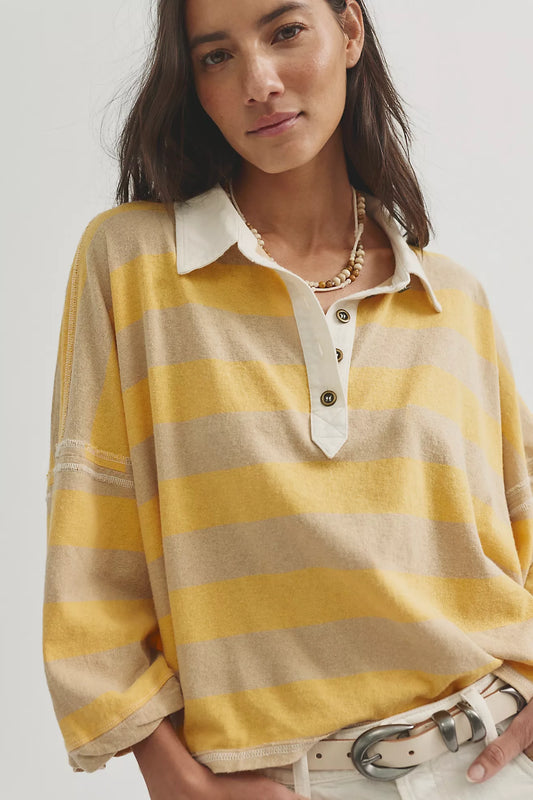 Woman wearing a yellow and beige striped shirt with a white collar.