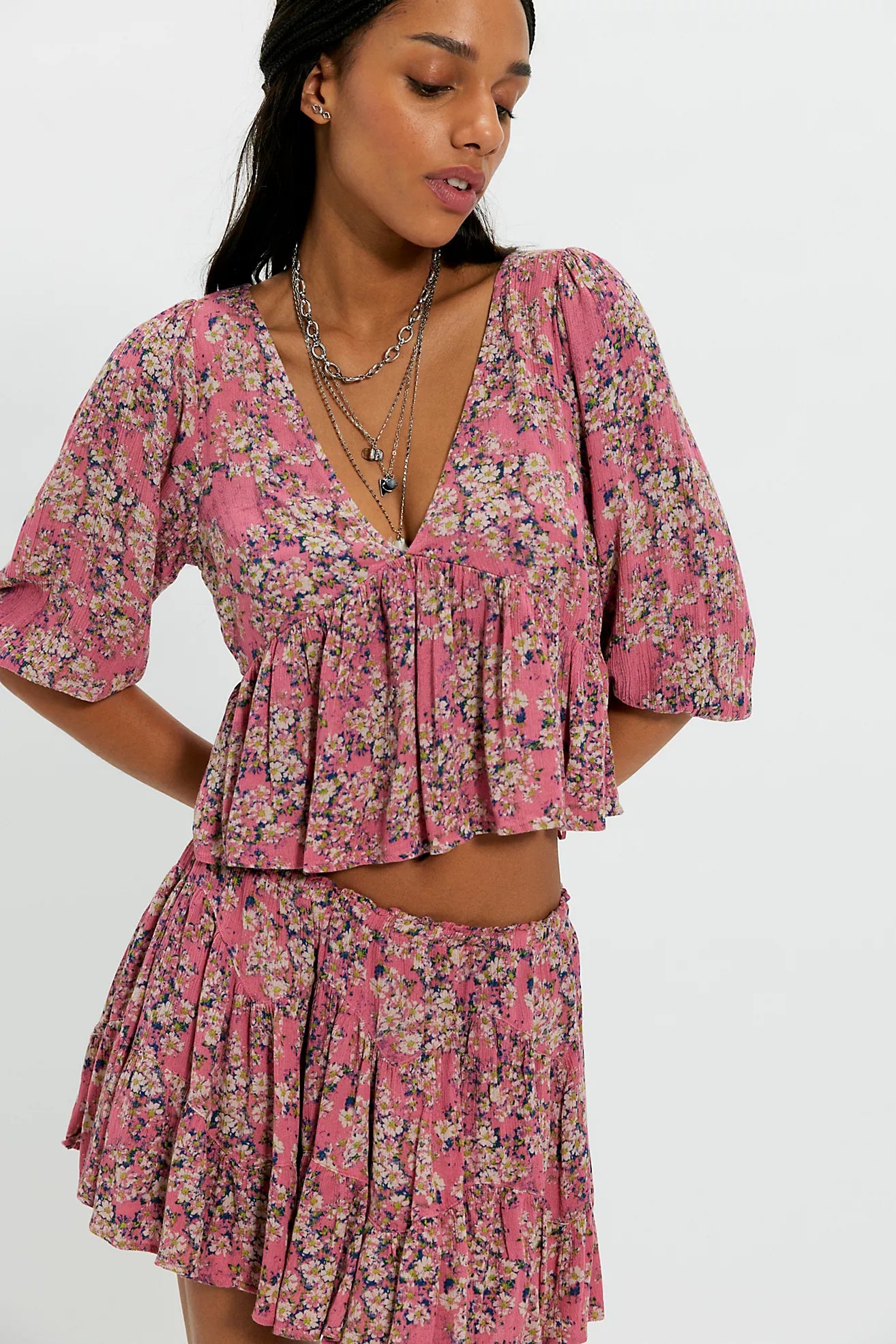 Woman wearing a pink floral dress on a white background