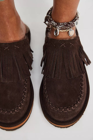 Brown suede loafers with fringe details on a white background