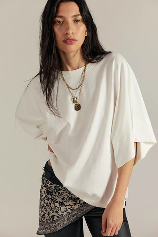 Women wearing a white top against a neutral background.